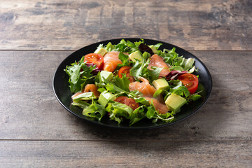 Salmon and avocado salad on rustic wooden table