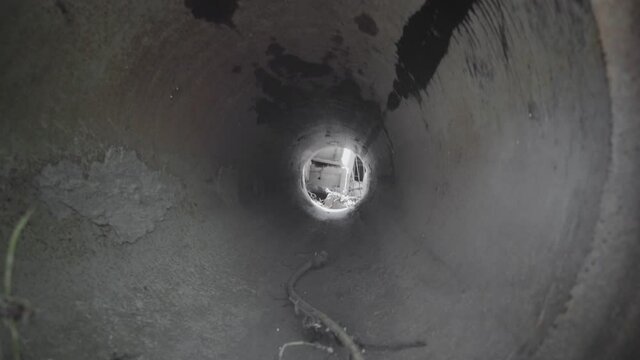 Exit from the dry drainage sewage tunnel pipe. Concrete Drainage Pipe, collector of city sewage system. Dolly.