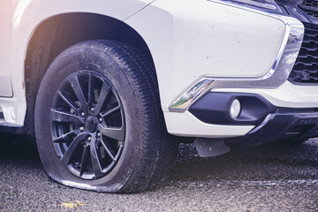 Close up of a car flat tire, air tire pressure lose on the road.