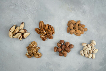 Many kinds of nuts close up. Heap of nuts on a gray concrete background.