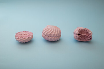 Sweet marshmallow lies on a blue background, minimalism, dessert