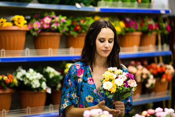 Portrait of a woman holding a bucket of flowers in a florist shop