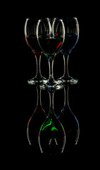 Three Elegant wine glasses a with blue red and green fluids in black background