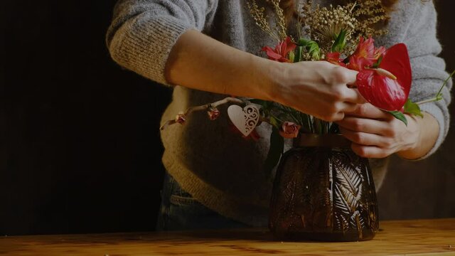 Florist makes flower arrangement for St. Valentines day. Florist at work. Valentines day floral composition, festive home decor. 