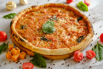 Appetizing, fresh pizza is on the table. Food from an Italian restaurant. Cooking pizza. Pizza ingredients.