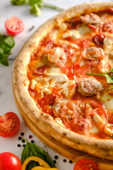 Appetizing, fresh pizza is on the table. Food from an Italian restaurant. Cooking pizza. Pizza ingredients.