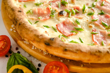 Appetizing, fresh pizza is on the table. Food from an Italian restaurant. Cooking pizza. Pizza ingredients.