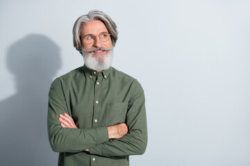 Portrait of attractive cheery grey-haired man corporate expert thinking copy space folded arms isolated over gray pastel color background