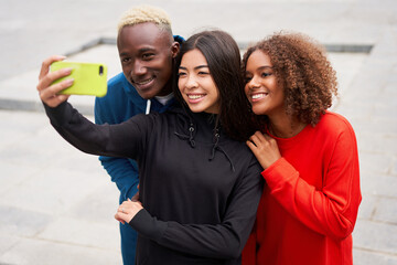 Multi ethnic friends outdoor taking a selfie on smartphone. Diverse group people Afro american asian spending time together Multiracial male female student meeting outdoors