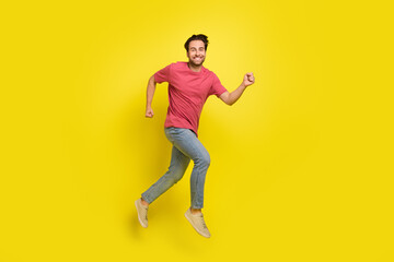 Fototapeta na wymiar Full size photo of impressed beard young guy run wear red t-shirt jeans sneakers isolated on yellow background