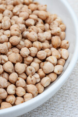 Bowl of Raw uncooked chickpeas on rustic surface