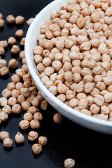 Bowl of Raw uncooked chickpeas on rustic surface