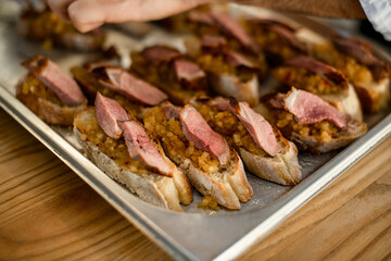 selective focus of appetizer - slices of white baguette with blend vegetable and slices of meat