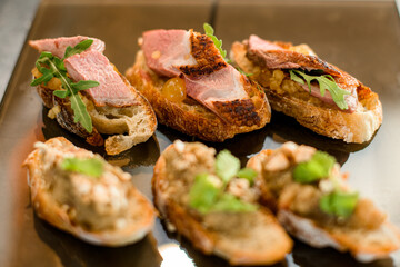 Close-up of delicious slices of meat decorated by parsley on white baguette slices