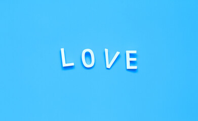 Fototapeta premium the word LOVE made of white letters on a pure blue background