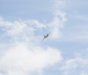 The plane is flying against the blue sky. Aerobatic figure, military aircraft.