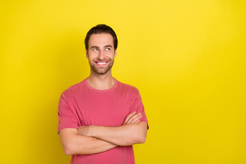 Photo of positive curious guy crossed arms look empty space wear pink t-shirt isolated yellow color background