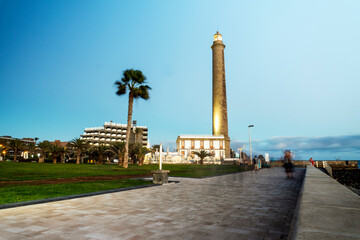 Obraz premium Lighthouse on rocky coast during sunset in Maspalomas, Gran Canaria, Spain