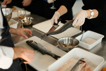 Obraz na płótnie Canvas hands of chef cuts the fish on a cutting board