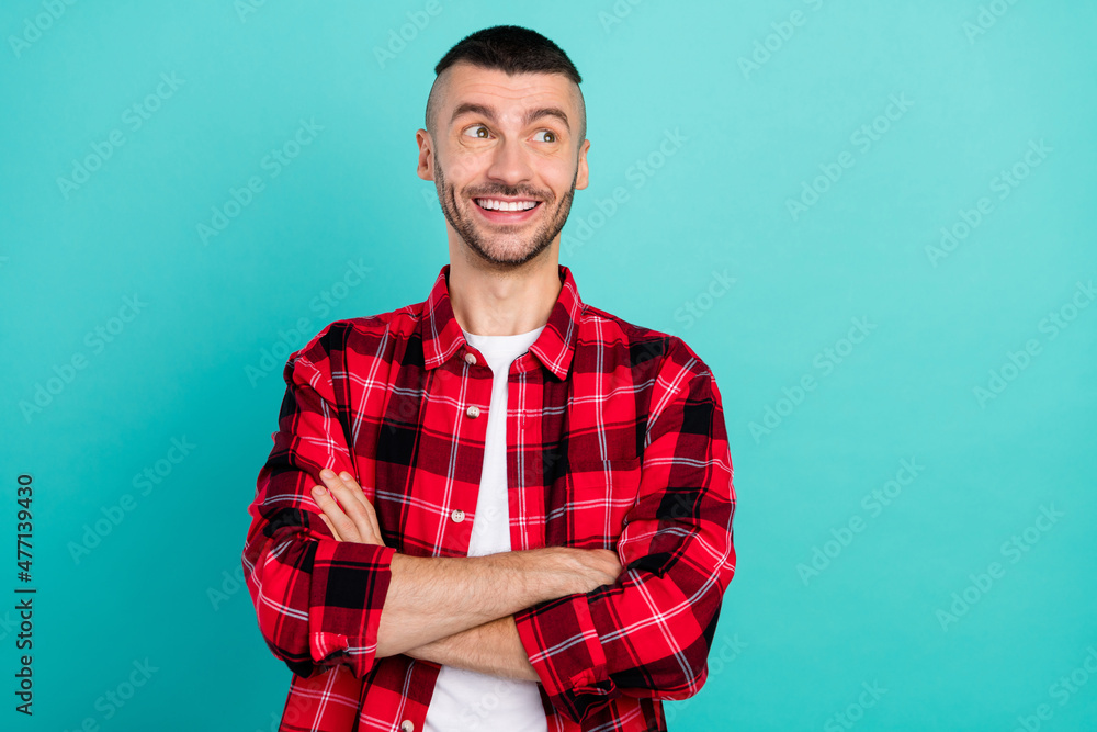 Sticker photo of positive happy dreamy young man look empty space hands crossed isolated on teal color backg