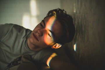 man with rainbow on eyes shadow and smiley nailpaint. LGBT concept. Teenagers problems, sad boy,...