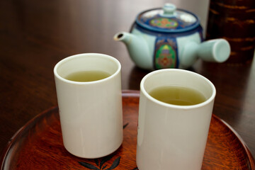 Fototapeta na wymiar 緑茶が注がれた二つの白いコップ