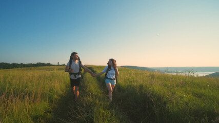 The two tourists walking with backpacks on a blue sky background