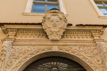 The coat of arms of the Archdiocese of Krakow above the building's door.