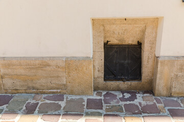 A wooden hatch in the facade of the building, chute for discharging coal into the basement.