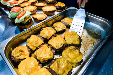 view of baked cutlets with melted cheese on a metal baking sheet