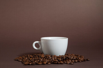 cup of coffee on a pile of coffee beans on a black background.