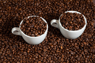 Fototapeta premium two cups of coffee on coffee beans on a brown background.