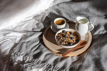Frühstück im Bett mit einer Schüssel Frühstücksflocken und eine Tasse Kaffee. Hygge, morgen.