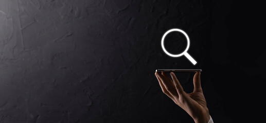 Male hand holding magnifying glass ,search icon on blue background. Concept search engine...