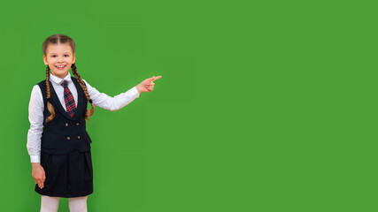 A student shows a cheerful student in a suit to your advertisement. getting an education in high school. isolated green background.
