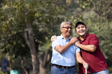 Cheerful grandfather spending leisure time with son at park
