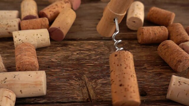 Wine corks and falling corkscrew on wooden old boards. Slow motion.