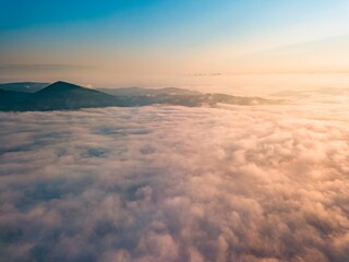 Fototapeta na wymiar High flight over the fog in the mountains. Ukrainian Carpathians in the morning. Aerial drone view.