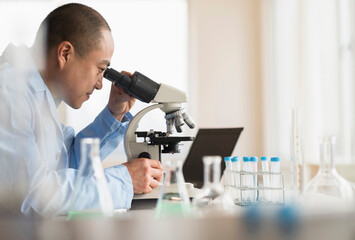 Korean scientist using microscope in laboratory