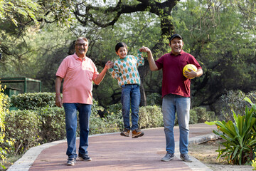 Cheerful three generation Indian family having fun together at park
