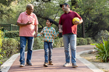 Cheerful three generation Indian family having fun together at park
