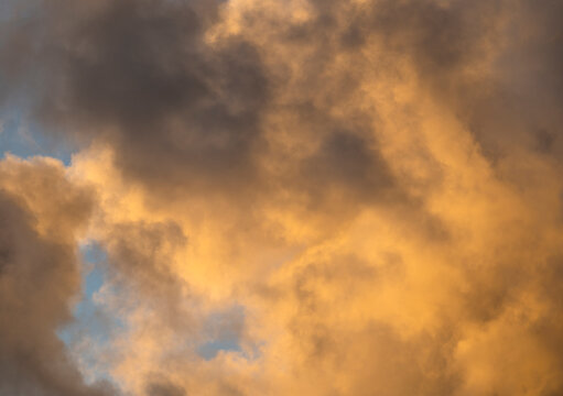 Golden Cumulus clouds on sky at sunset