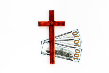 Money and religion. Wooden cross on dollars