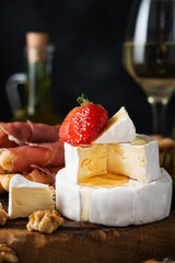 Brie cheese, camembert, grissini, jamon, wine, nuts, honey. Snacks for wine.