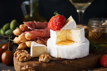 Brie cheese, camembert, grissini, jamon, wine, nuts, honey. Snacks for wine. Italian snacks