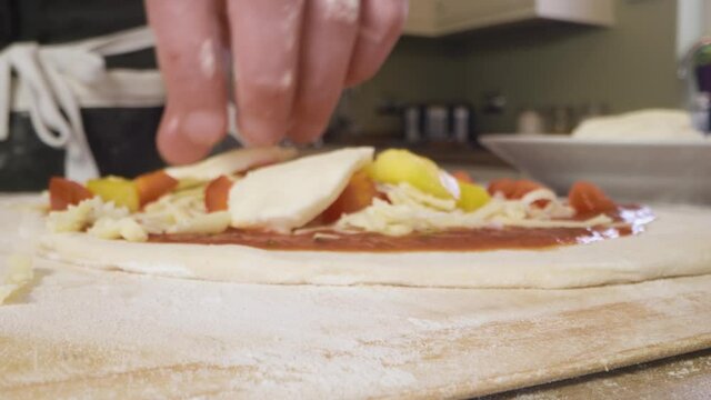 Close Up Putting Mozzarella on Pizza Dough. High quality video footage