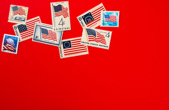 American flag postage stamps against red background