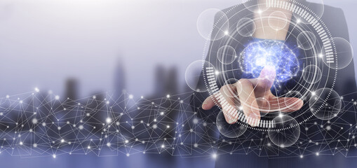 The modern concept of the cyberbrain. Hand touch digital screen hologram Brain sign on city light blurred background.