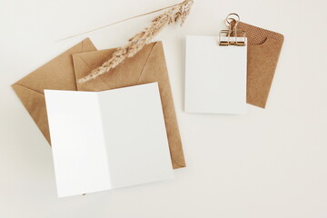Blank white card paper with kraft brown envelopes template mock up . Flat lay, top view.