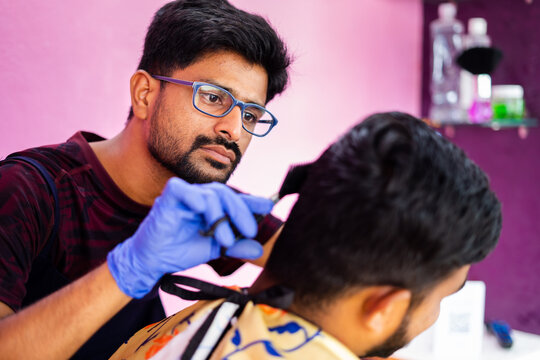 Close up shot of hairdresser busy in haircut at salon - concept of haircare, professional occupation and small business.